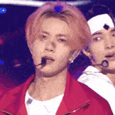 a man with pink hair is wearing a red jacket and a headband