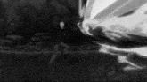 a black and white photo of a man in a suit standing in front of a huge explosion .