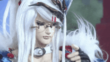 a doll with long white hair and glasses is holding a feather .