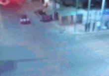 a car is driving down a street with a building in the background
