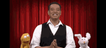 a man is standing on a stage with two stuffed animals behind him .