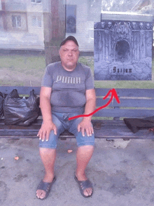 a man wearing a puma shirt sits on a bench in front of a poster for sodium