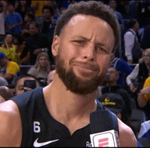 a basketball player with a beard is making a funny face while talking to a microphone .