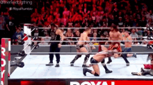 a group of men are wrestling in a wrestling ring with a crowd watching .