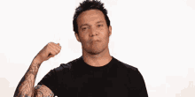 a man with tattoos on his arm giving a thumbs up