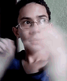 a young man wearing glasses is making a funny face