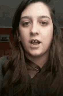 a young woman with a missing tooth looks at the camera