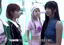 three girls are standing next to each other with yunjin in the corner