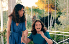 a woman in a blue dress stands next to another woman in a blue dress with the word sophie on the bottom