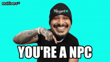 a man wearing a beanie that says blizzard on it smiles and says you 're a npc