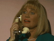 a woman talking on a telephone with a surprised expression on her face