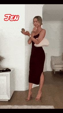 a woman in a black dress is standing in a room with the name jen on the wall