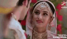 a man and a woman are standing next to each other and the woman is wearing a veil .