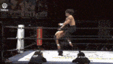a man is wrestling another man in a wrestling ring while a woman watches .