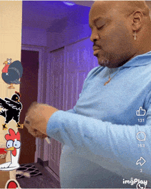 a man in a blue shirt is standing in front of a cartoon chicken and turkey
