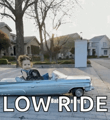 a little girl is sitting in a toy car with the words low ride below her