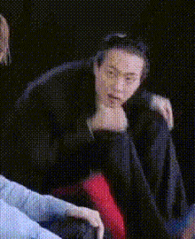 a man is sitting in a chair with his head down and his eyes closed .