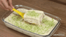a person is taking a piece of food out of a casserole dish that says made in animotica on the bottom