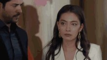 a man and a woman are standing next to each other in a room .