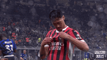a soccer player wearing a jersey that says emirates