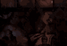 a group of people are standing in a dark room .