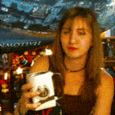 a woman is holding a mug in front of a poster that says hallowe