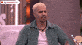 a man in a green shirt is sitting in front of a youtube logo