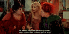 three women are standing next to each other and one of them is talking about halloween