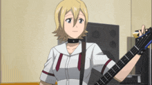 a girl holding a guitar in front of a speaker