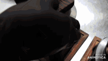 a person is cutting something with a knife and the words made in animotica can be seen in the corner