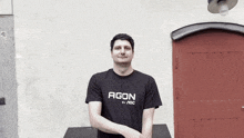 a man wearing a black shirt that says agon on it
