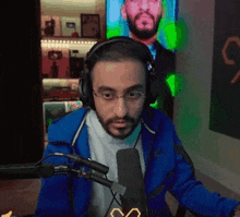 a man wearing headphones and glasses is talking into a microphone .