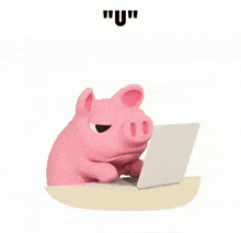 a pink pig is sitting at a desk using a laptop computer .