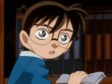 a boy wearing glasses is looking at something