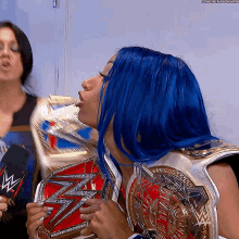 a woman with blue hair is holding a wrestling belt