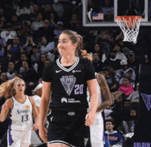 a female basketball player wearing a black jersey with the number 20 on it