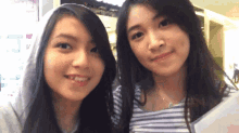 two girls are posing for a picture and one has a hood on her head