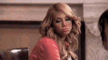 a woman is making a funny face while sitting at a table with her mouth open .