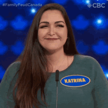 a woman with katrina on her shirt stands in front of a microphone