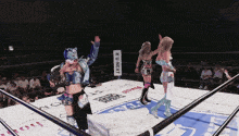 two women in a wrestling ring with a u-next sign in the corner