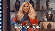 a woman is standing in front of a group of people and says `` hope all is well , how you doin '' .
