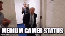a man in a suit and tie is walking through a hallway with the words medium gamer status written on the bottom