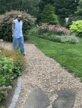 a man wearing headphones stands in a garden