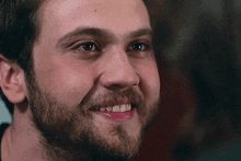 a close up of a man with a beard smiling with his mouth open