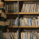 a person is standing in front of a bookshelf filled with books .