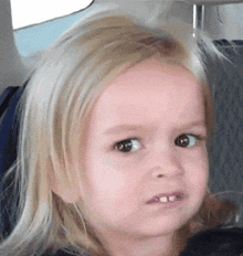 a little girl is making a funny face with her eyes closed