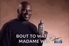 a man is holding a bottle of shampoo and smiling while talking about madame web .