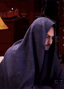 a man is wrapped in a blue blanket with the letters ct on the bottom