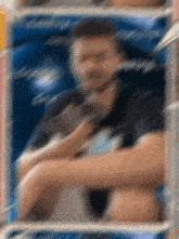 a blurry picture of a man in a black shirt with a blue background
