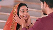 a man is touching a woman 's face with his hands